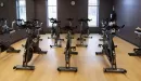 Thumbnail: Cycling room with spin bikes placed throughout room. Dark painted walls.