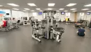 Thumbnail: Large, open area for stretching and exercising. Yoga mats hanging on wall. Some fitness machines along wall. Open floorspace for stretching.