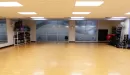 Thumbnail: Group exercise studio with equipment for classes, including medicine balls, chairs for senior classes, and yoga equipment.