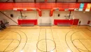 Thumbnail: One-court gymnasium with small sets of bleacher seating along walls. Indoor track overhead of gymnasium. 