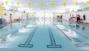 Thumbnail: Indoor pool with up to 6 lap lanes. Pool weights and kickboards in bins beside pool. Separate whirlpool in back of pool area.