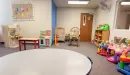 Thumbnail: Child care room with toys, small tables and chairs, and a rocking chair.