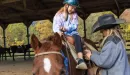 Thumbnail: a girl gets saddled up to go horseback riding at ymca trout lodge