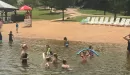 Thumbnail: Families playing in the lake by the sandy beach