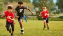Thumbnail: ymca youth flag football participants run trying to catch the player in front of them