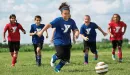 Thumbnail: ymca youth soccer participants dribbling a soccer ball down the soccer field