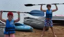 Thumbnail: Young boys holding kayak paddles above their heads