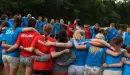 Thumbnail: Staff form a circle with arms around each other