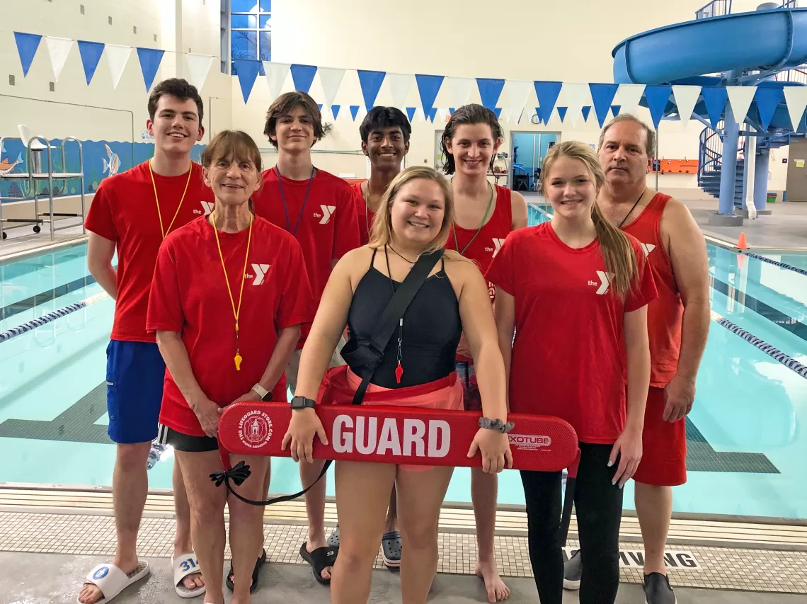 A group of lifeguards next to an indoor pool