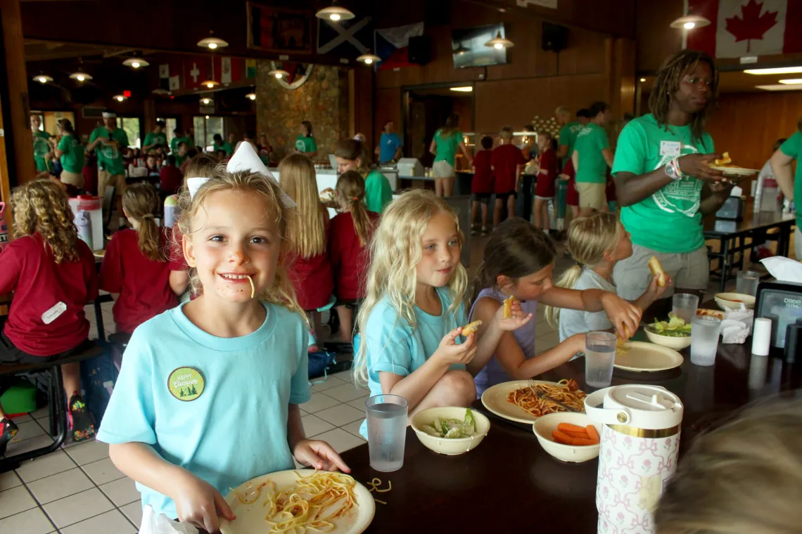 A happy camper laughing while enjoying the famous 'utensils optional' Sunday Night Spaghetti dinner.