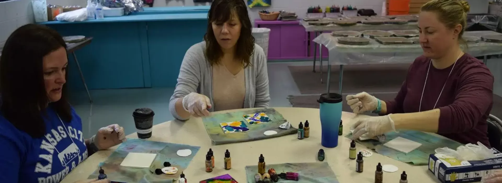Three women painting at table