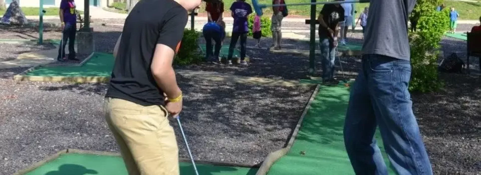 Two boys playing mini golf