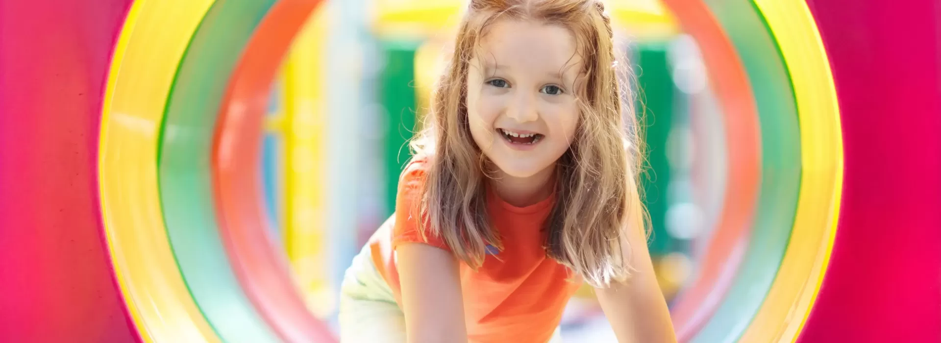 girl having fun climbing through tube