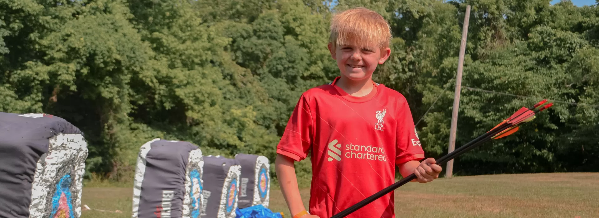 young boy retrieving his arrows at the archery range