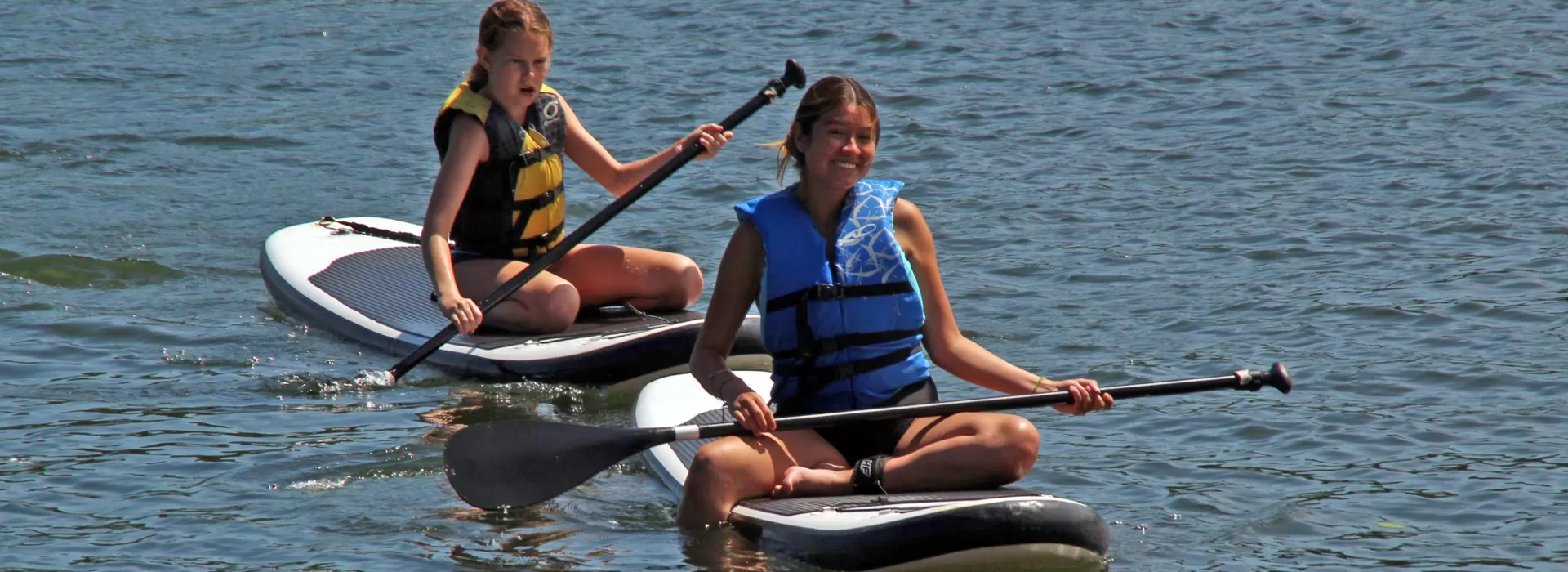 two girls paddle boarding