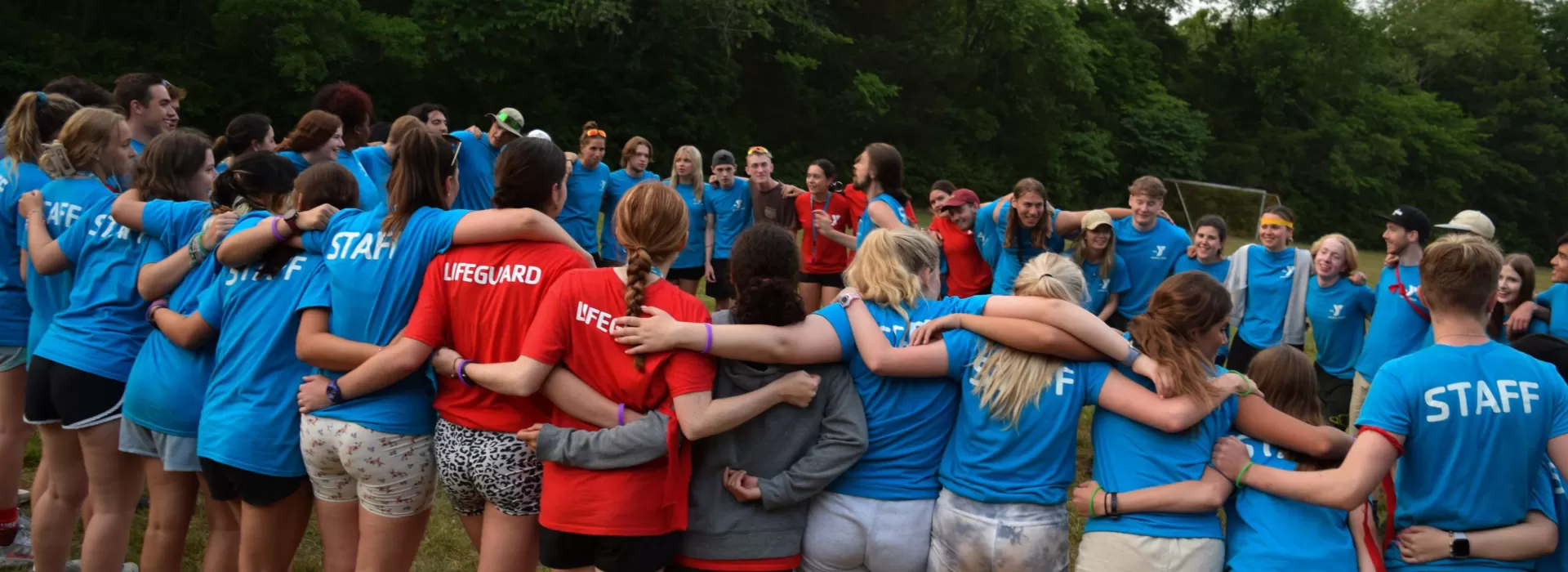 Staff form a circle with arms around each other